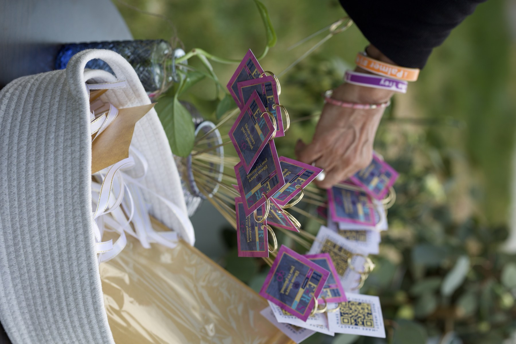 Hands arranging remembrance tags in a basket