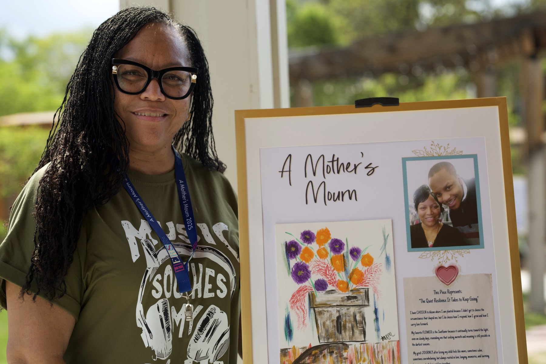 An attendee beside a memorial artwork from A Mother's Mourn